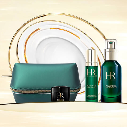 Image of HR skincare sets. It includes two green bottles labeled "POWERCELL SKINMUNITY" and a miniature of Age Recovery Night. A pouch is also included. The products are displayed on a swirling gold and white background.​